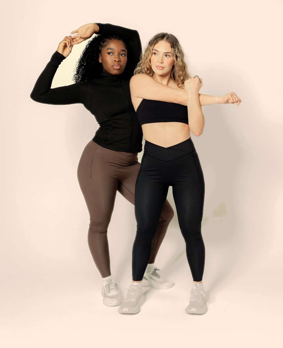 Two women stretching in compression leggings